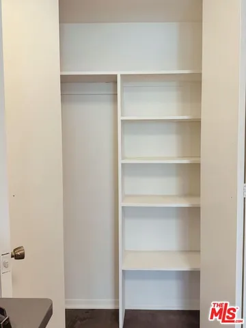 a view of walk in closet with empty racks