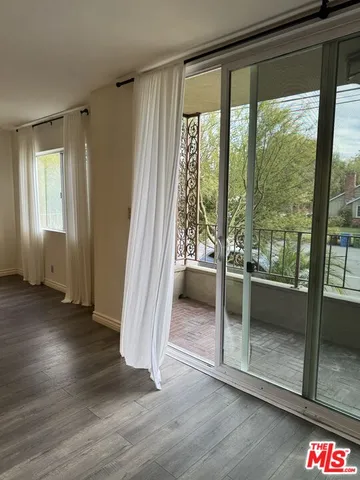 a view of a room with wooden floor and windows