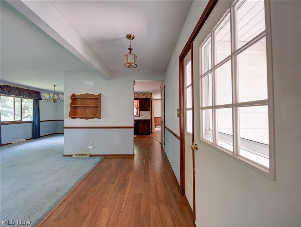 11430 Ferry Road Chesterland, OH 44026 - Photo 8 of 38 Hall featuring hardwood / wood-style floors and a chandelier