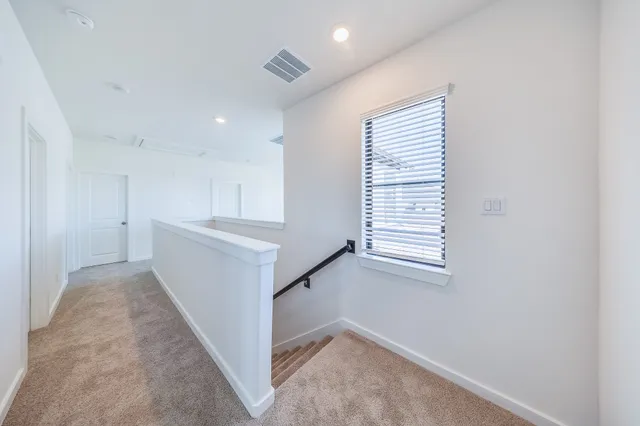 a view of hallway with stairs and a window