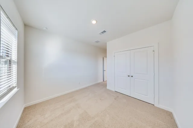 an empty room with windows and closet