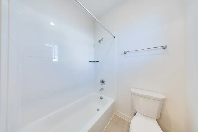 a white toilet sitting next to a bath tub