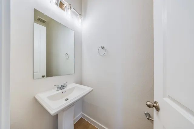 a bathroom with a sink mirror and vanity