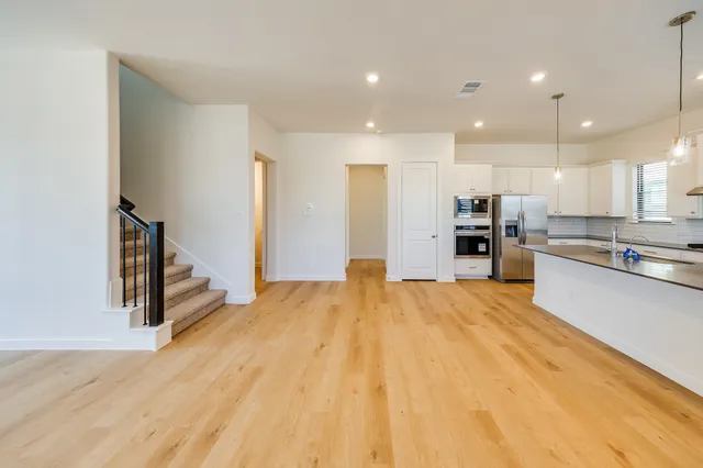 a large kitchen with stainless steel appliances kitchen island a large counter top and a stove top oven