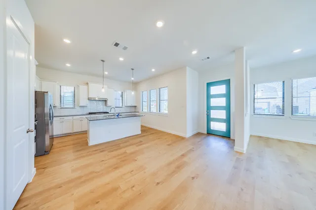 a large kitchen with kitchen island a refrigerator sink and cabinets