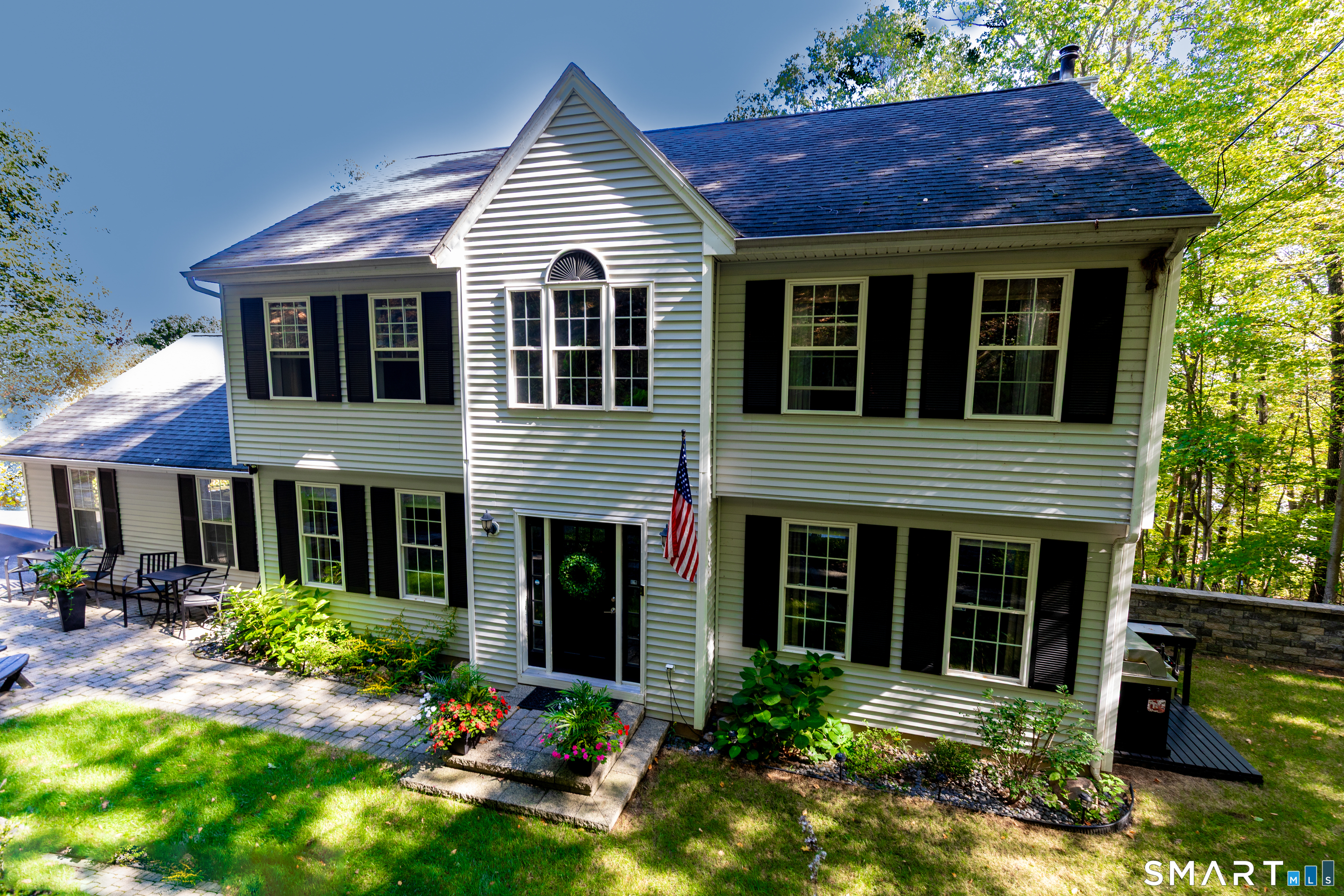 a view of a house with potted plants and a yard