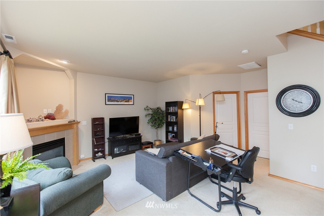 6745 Southeast 5th Street Renton, WA 98059 - Photo 11 of 25 a living room with furniture a fireplace and a flat screen tv