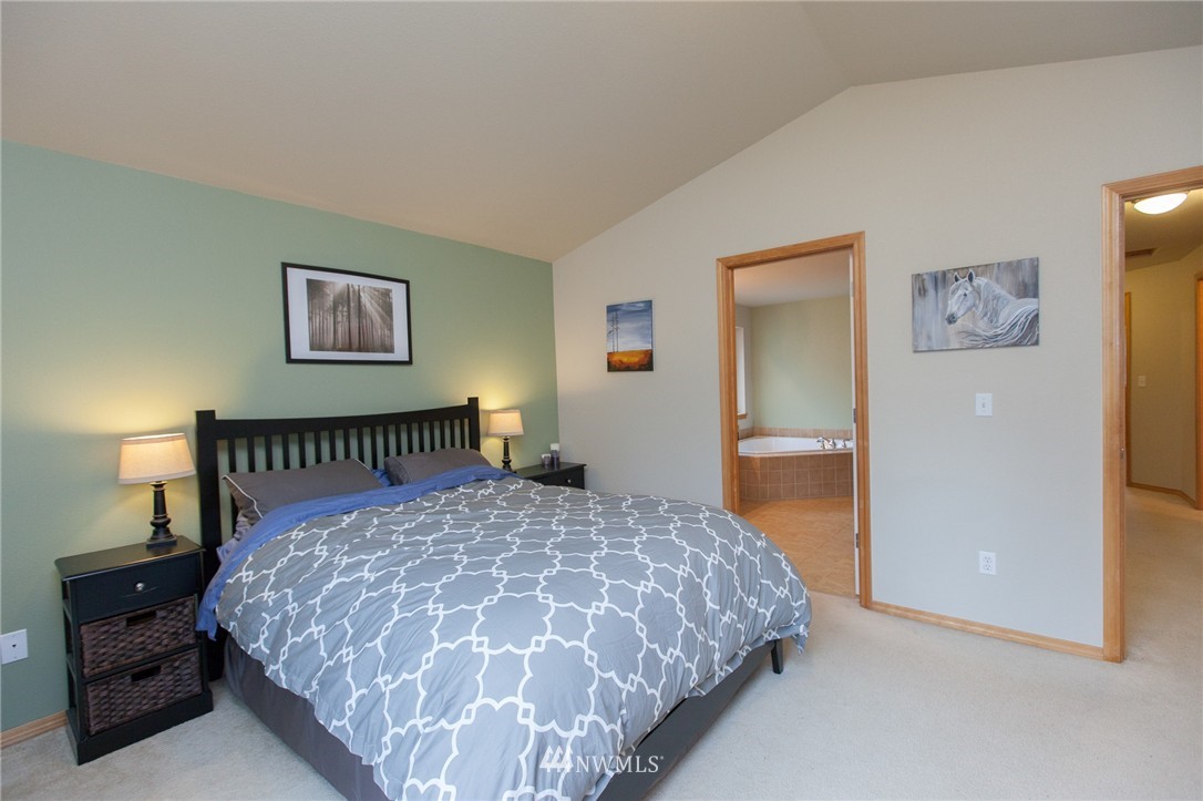 6745 Southeast 5th Street Renton, WA 98059 - Photo 15 of 25 a bedroom with a large bed and a chandelier