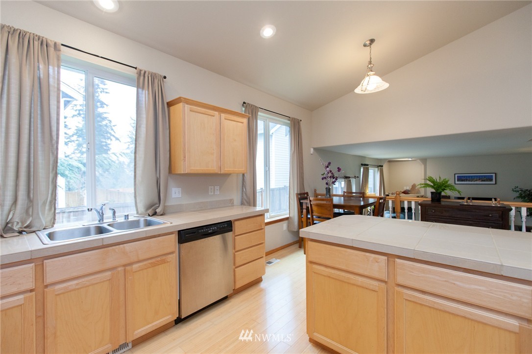 6745 Southeast 5th Street Renton, WA 98059 - Photo 5 of 25 a large kitchen with kitchen island a sink appliances and a large window
