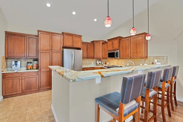 a kitchen with stainless steel appliances granite countertop a stove a sink and a microwave