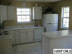 8320 Rudolph Road Charlotte, NC 28216 - Photo 3 of 8 a kitchen with a sink a refrigerator and window
