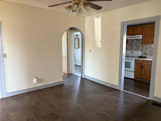 an empty room with a fireplace and chandelier