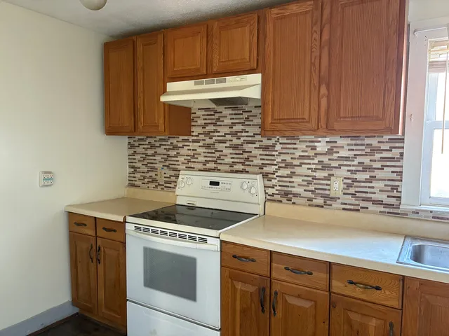 a kitchen with granite countertop cabinets stainless steel appliances and a sink