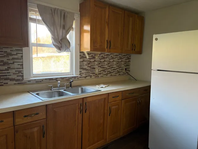 a kitchen with a sink a refrigerator and window