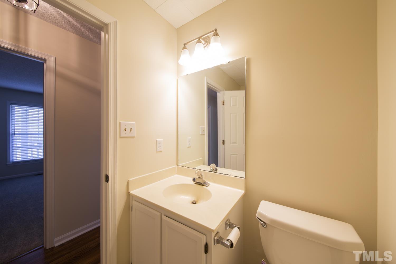 11805 North Exeter Way Raleigh, NC 27613 - Photo 11 of 19 a bathroom with a toilet a sink a mirror and vanity
