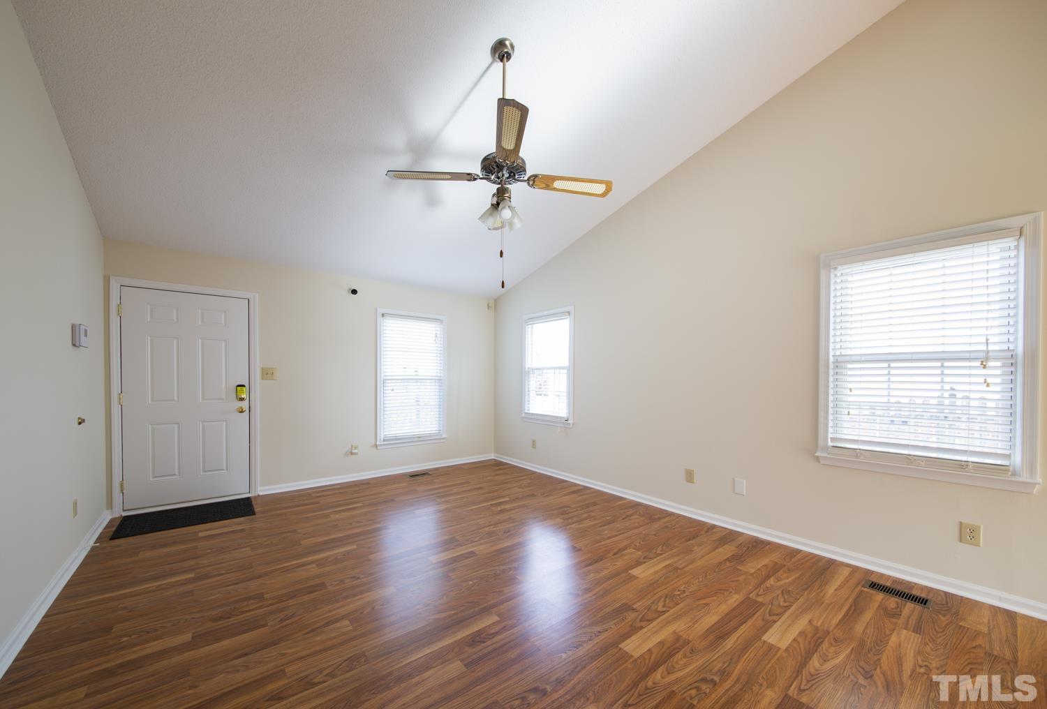 11805 North Exeter Way Raleigh, NC 27613 - Photo 5 of 19 an empty room with wooden floor ceiling fan and windows