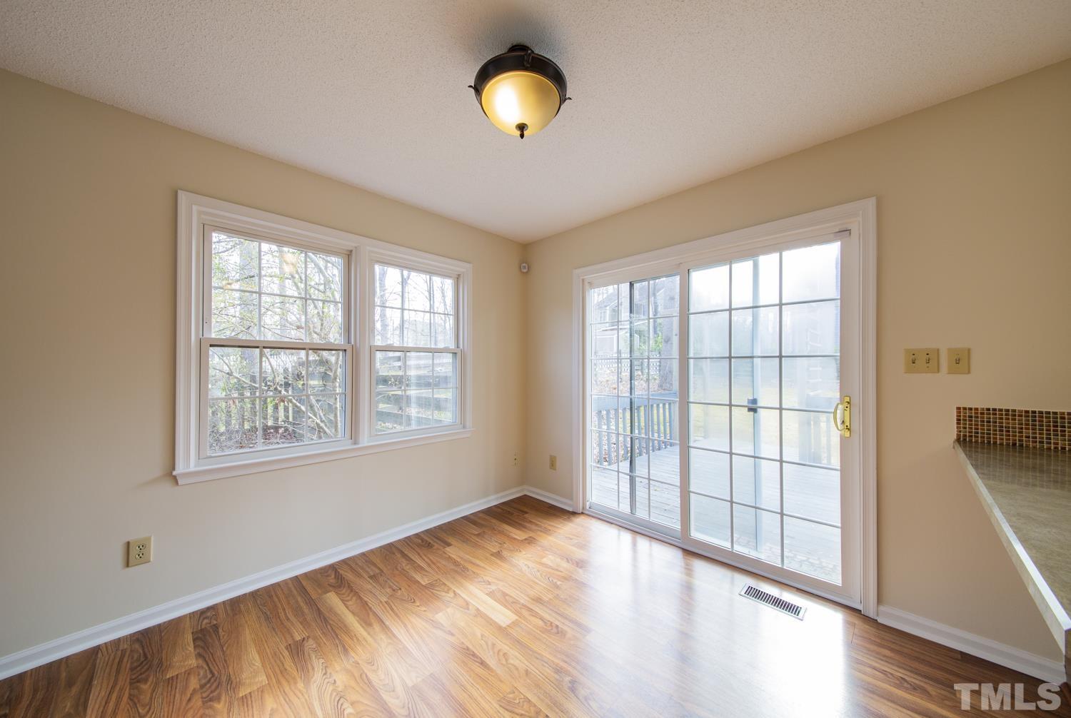 11805 North Exeter Way Raleigh, NC 27613 - Photo 7 of 19 a view of an empty room with wooden floor and a window