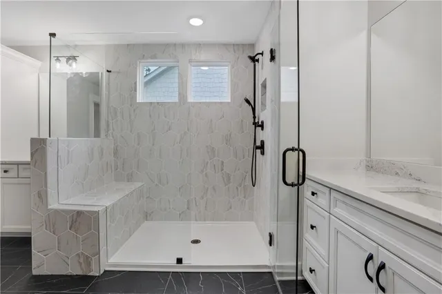 an empty room with wooden floor fireplace cabinet and windows