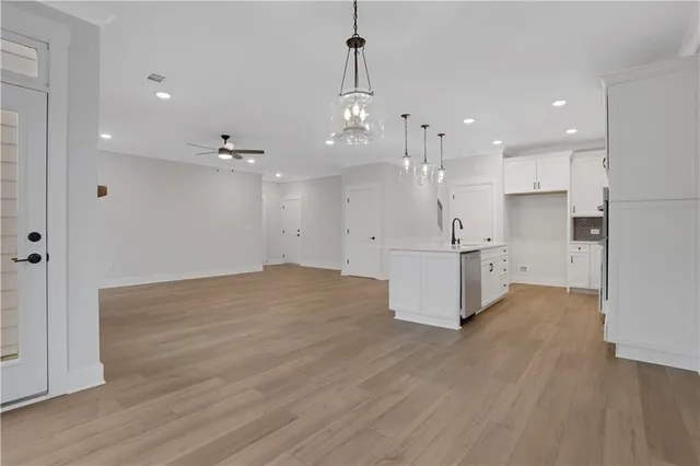 an empty room with windows and fan