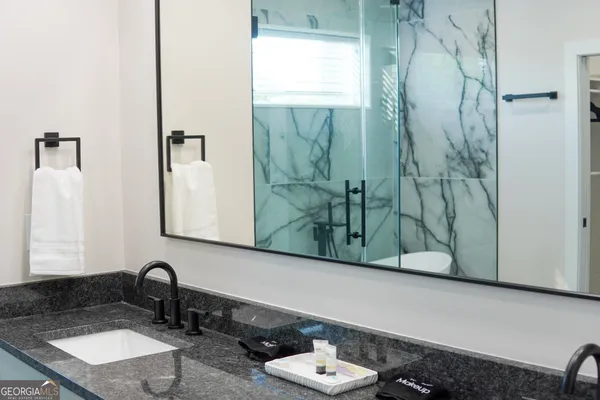 a bathroom with a granite countertop sink and a mirror