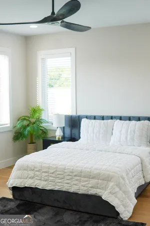 a large bed sitting in a bedroom next to a window