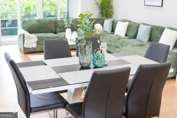 a kitchen with stainless steel appliances kitchen island a table chairs and a refrigerator