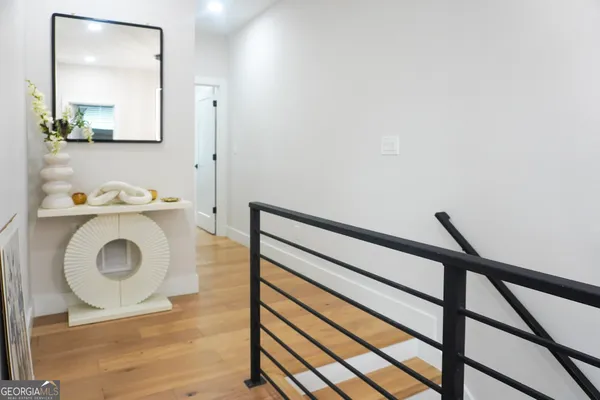 a view of a hallway with wooden floor and stairs