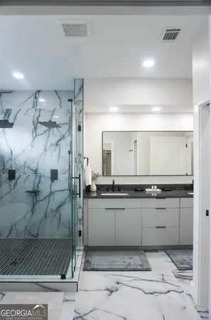 a bathroom with a granite countertop sink mirror and shower