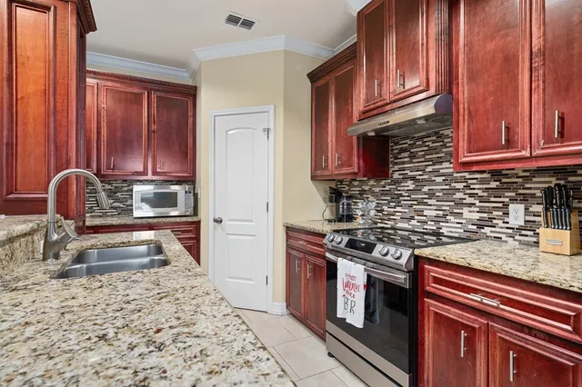 a kitchen with granite countertop a stove and a sink