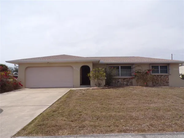 a front view of house with yard and trees in the background