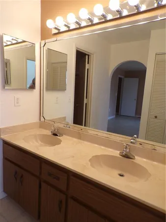 a bathroom with a granite countertop sink and two mirror