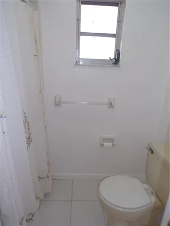 a white toilet sitting next to a bathroom sink and a window