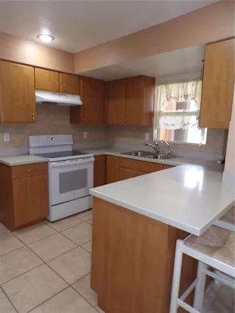a kitchen with a sink a stove and cabinets