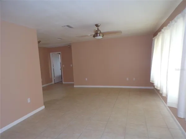 an empty room with windows and fan