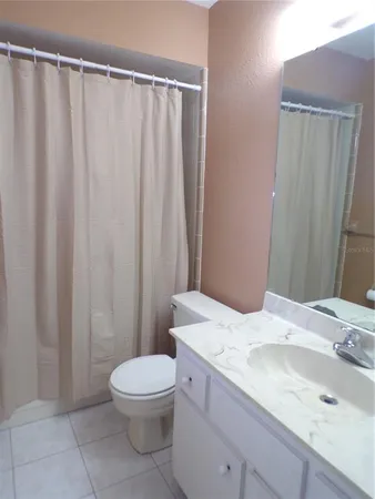 a bathroom with a granite countertop sink toilet and a mirror