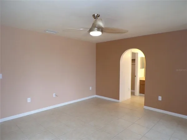 a view of an empty room with a chandelier fan