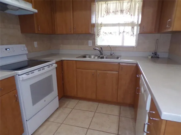 a kitchen with a stove sink and cabinets