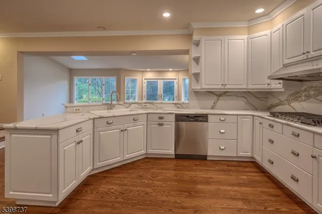 a kitchen with granite countertop a sink window and cabinets