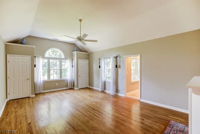 a view of a livingroom with wooden floor and a ceiling fan