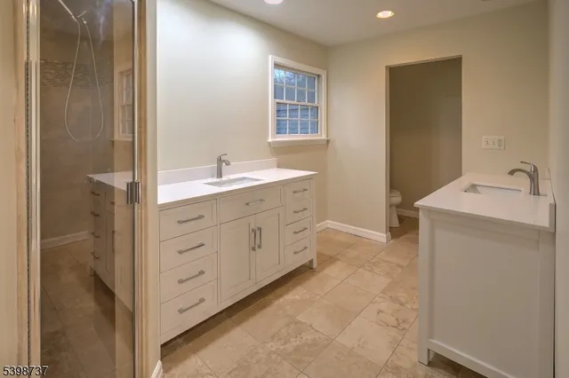a spacious bathroom with a double vanity sink a mirror and a bathtub