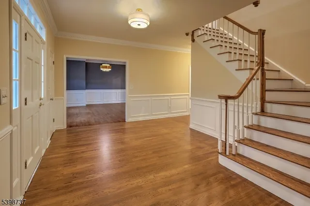 a view of a hallway with wooden floor and staircase