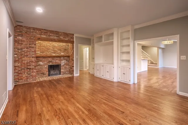 a view of empty room with wooden floor and fireplace