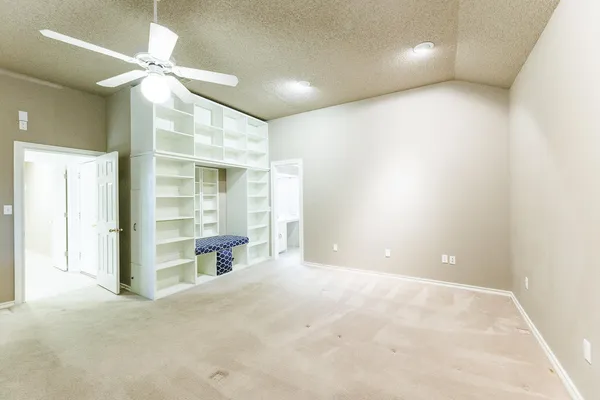 a view of an empty room with a ceiling fan