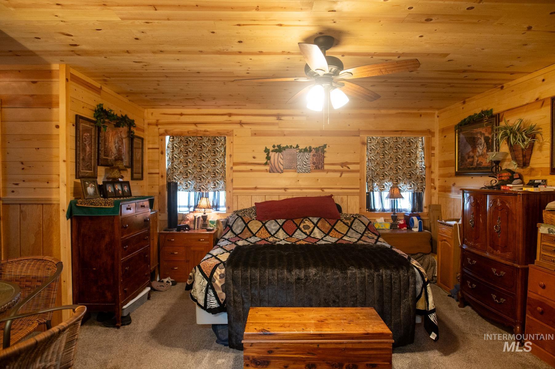 736 East Main Street Weiser, ID 83672 - Photo 22 of 33 Wood-paneled room featuring a ceiling fan with integrated lighting, wood-finish walls, and plush carpeting