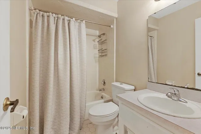 a bathroom with a granite countertop sink toilet and a mirror