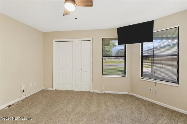 an empty room with windows and closet