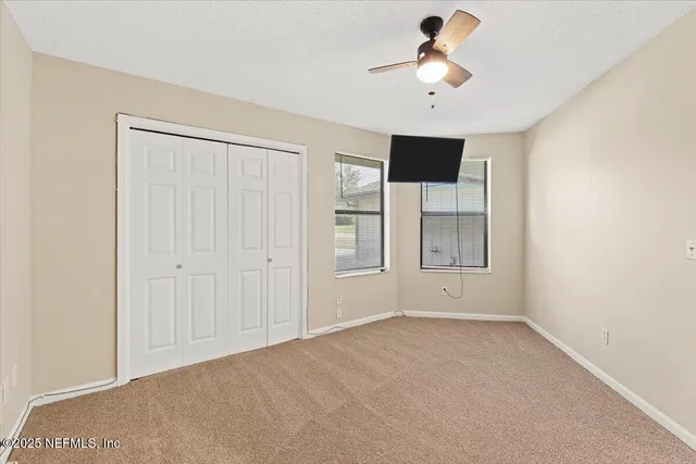 a view of empty room with ceiling fan