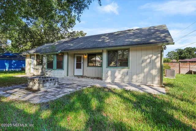 a view of a chair and table in backyard of the house