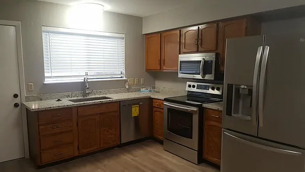 a kitchen with stainless steel appliances granite countertop a stove a sink and a refrigerator