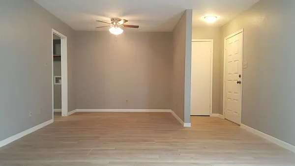 a view of an empty room with closet and a chandelier fan